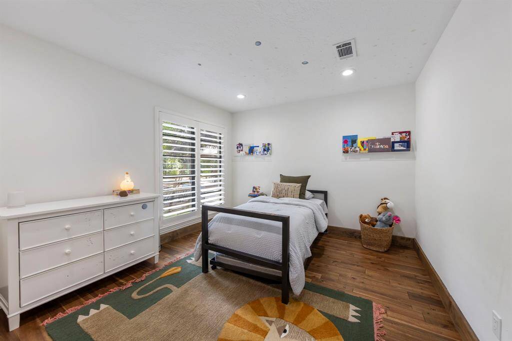 Additional secondary bedroom features plantation shutters over the window, neutral paint and recessed lighting.