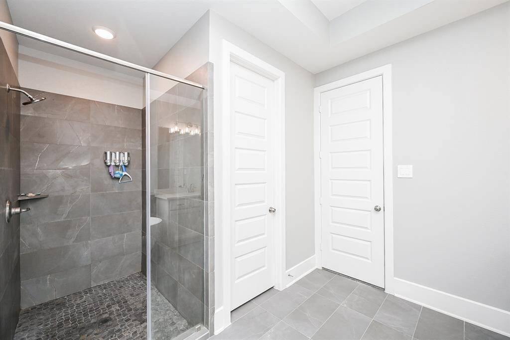 The primary walk in shower is spacious and peaceful with desert toned tile surround.