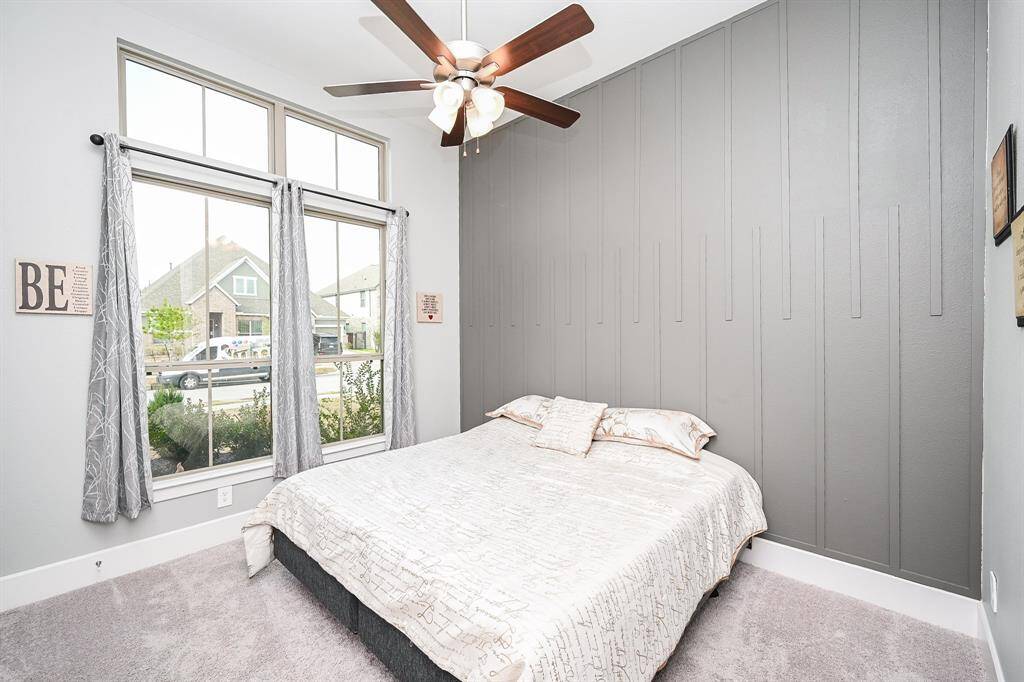 A spacious carpeted secondary bedroom on the 1st floor enjoys tremendous natural light.