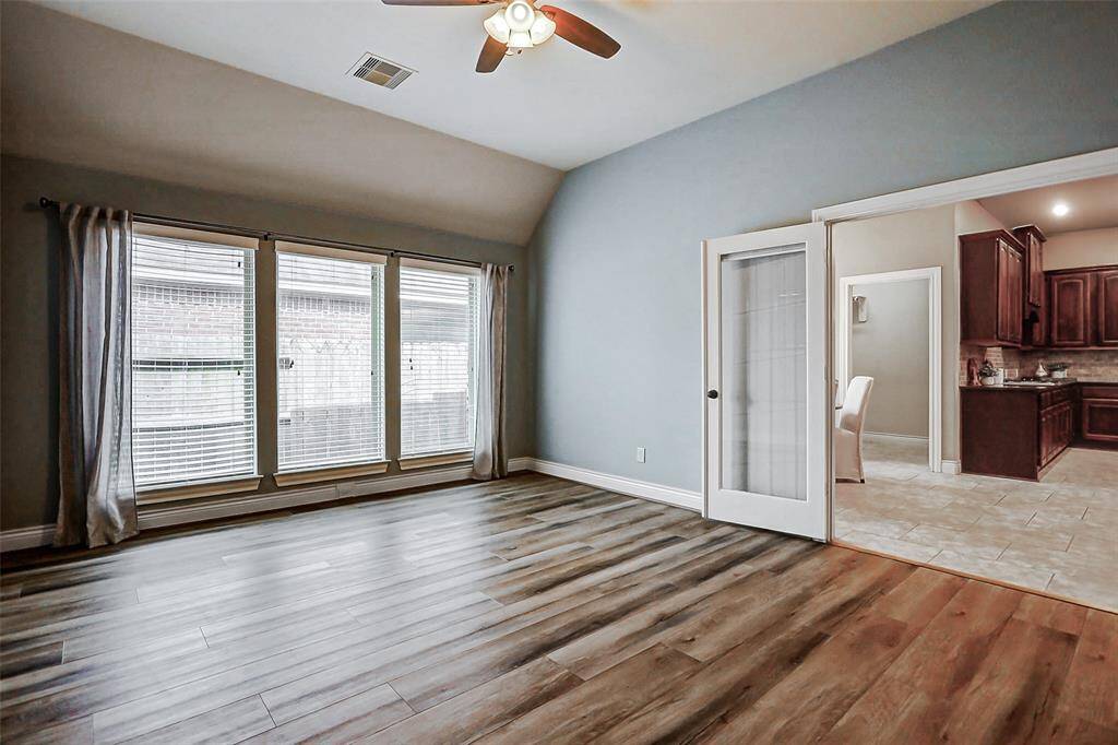 The large game room is located off the breakfast area and features wood floors, French doors and a wall of windows.