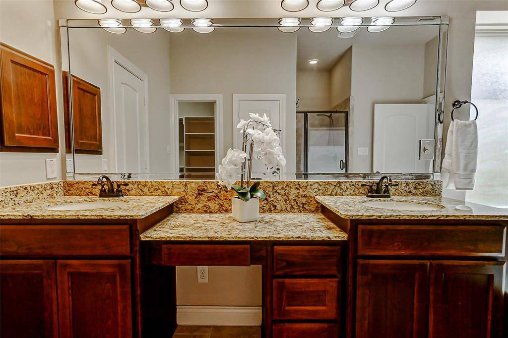 Dual sinks, a vanity and lots of cabinet space make this primary bathroom a dream.