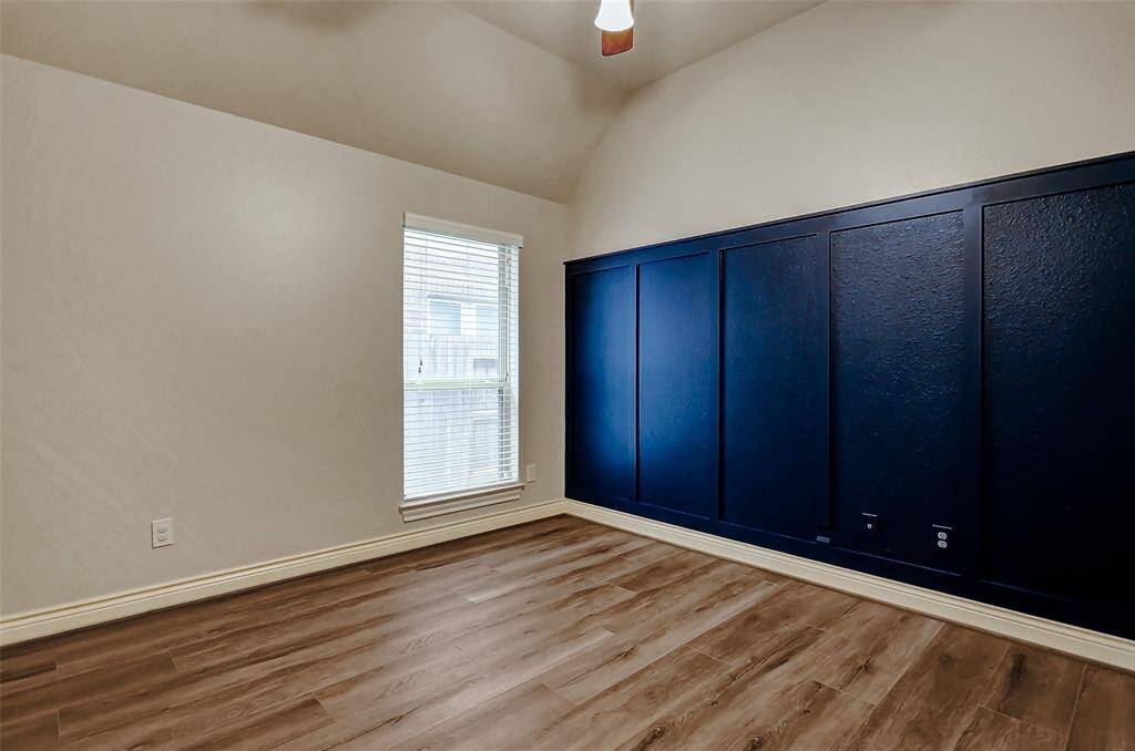One of the secondary bedrooms features a navy wall accent and has a walk-in closet.