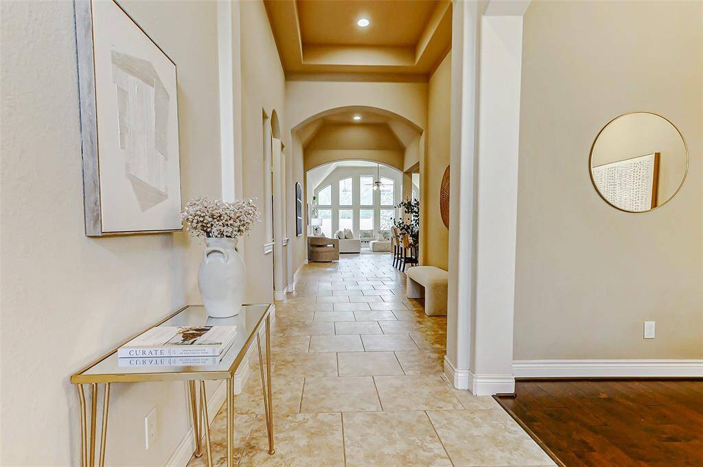 The hallway leads to a living area with large windows, creating an inviting and open feel.