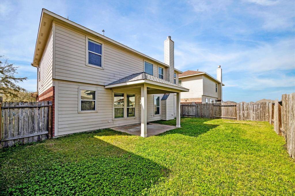 Covered patio area, ideal for outdoor activities, and has a well-maintained lawn