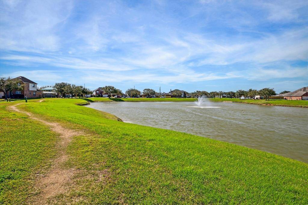 Lake with water foundation just off the corner of the home with a walking and jogging trail