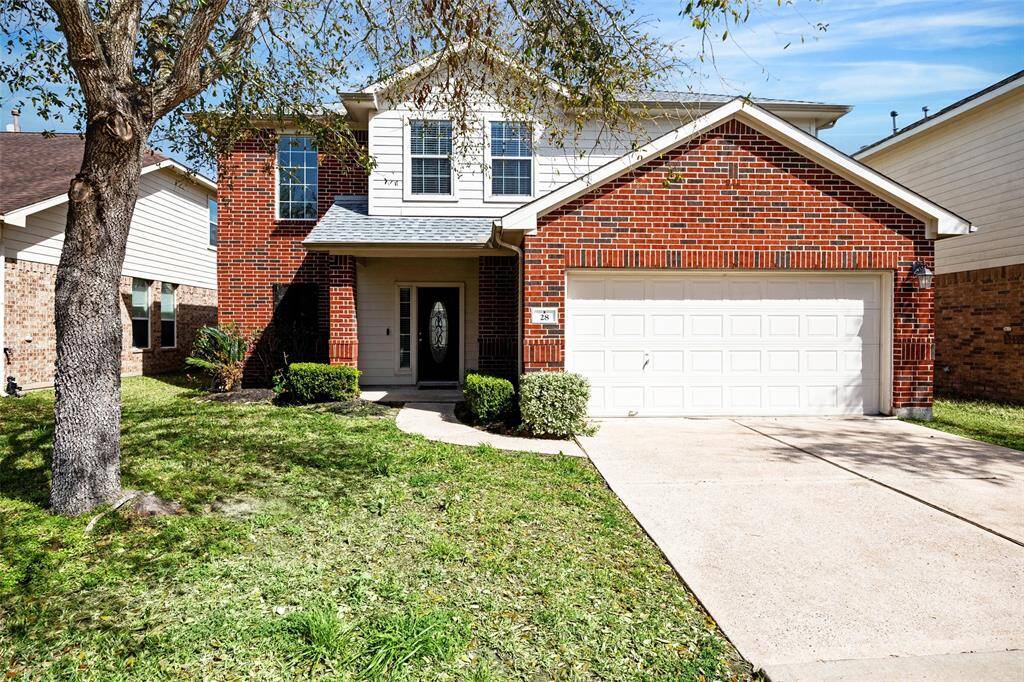 Stunning two-story brick home with a welcoming front porch, two-car garage, and well-maintained lawn