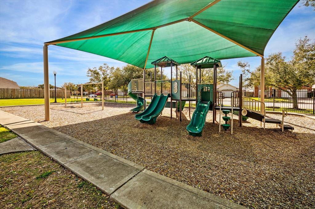 This photo features a well-maintained playground with slides and swings