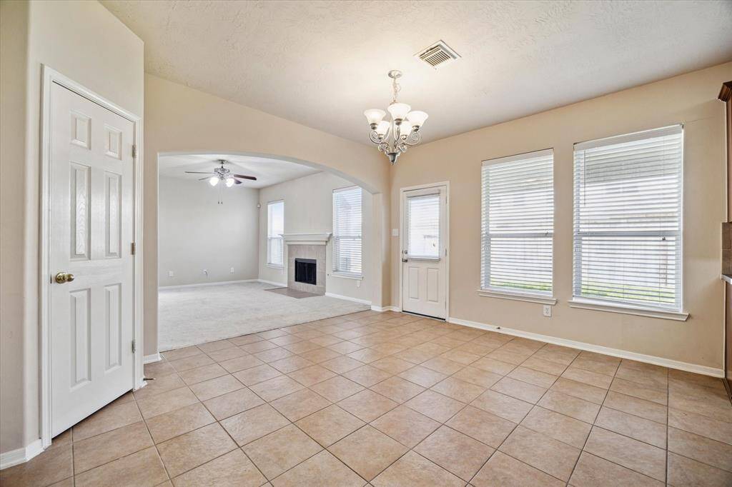 Large windows provide ample natural light, and a chandelier adds elegance to the dining space