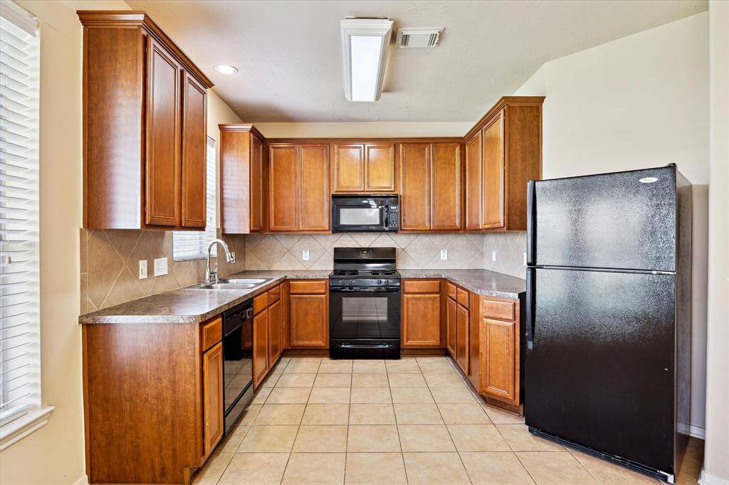 This kitchen features warm wooden cabinets with ample counter space and natural light