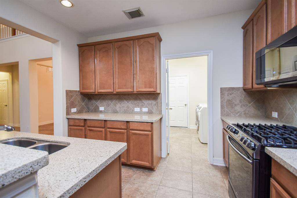 Conveniently located  laundry room, with tile flooring throughout for easy maintenance plus a water pluming manifold for those emergencies!