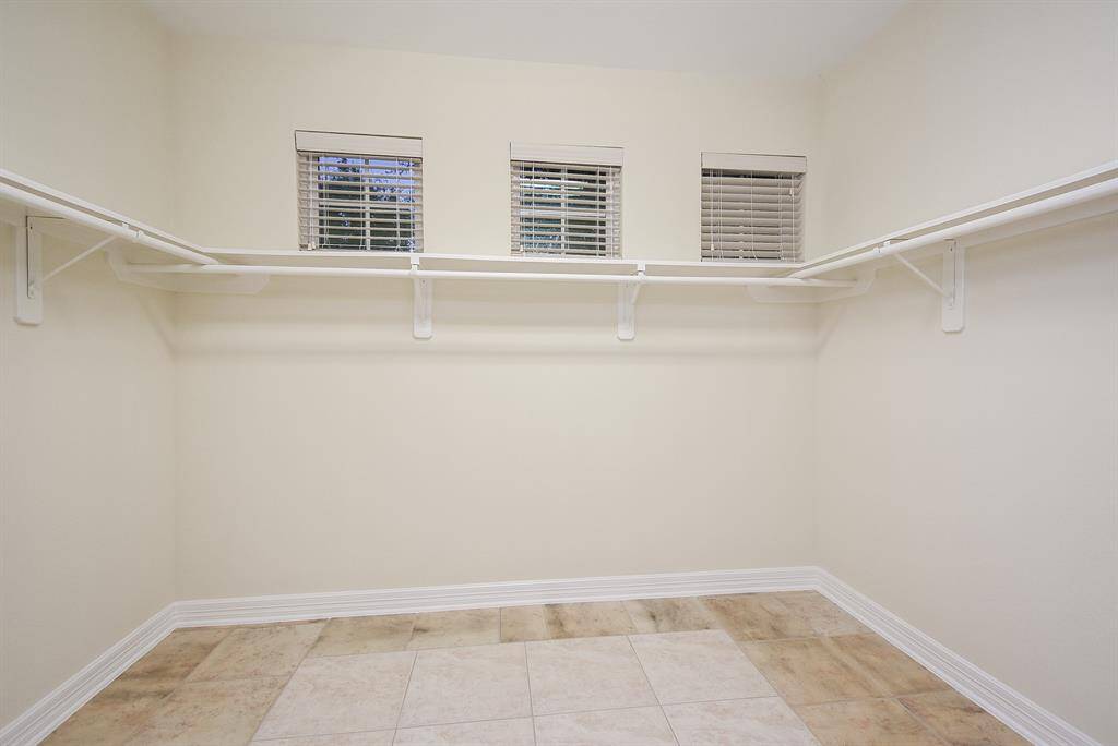 This spacious walk-in closet has lots of natural light with its three privacy windows.