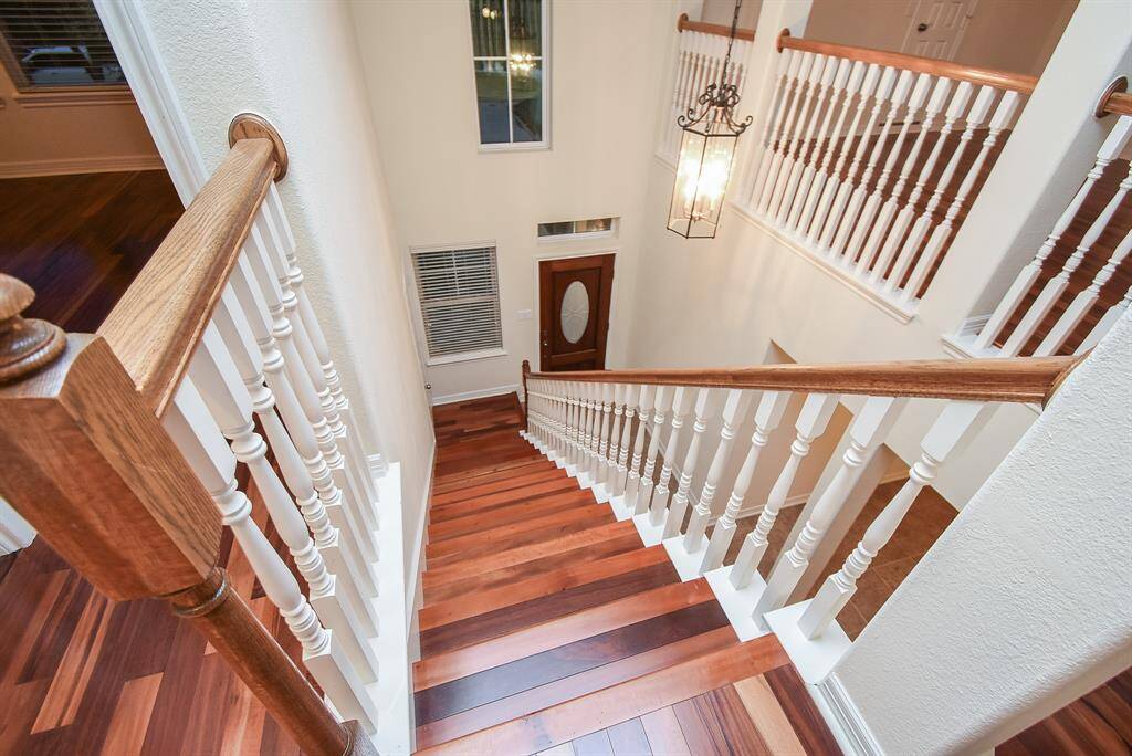 Enjoy this well-lit stairway with wood steps and white railings!  It opens the area so well!