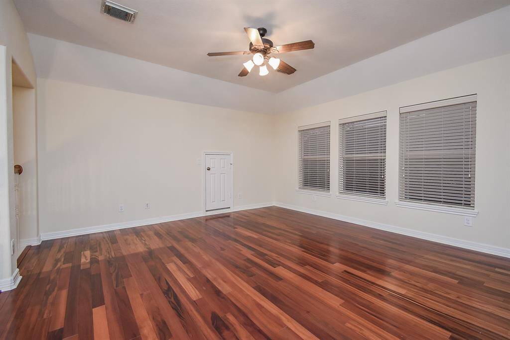 Game room area with wood flooring and more windows!  This home does not need much light during the day.  You will enjoy so much natural light!  Come and see!