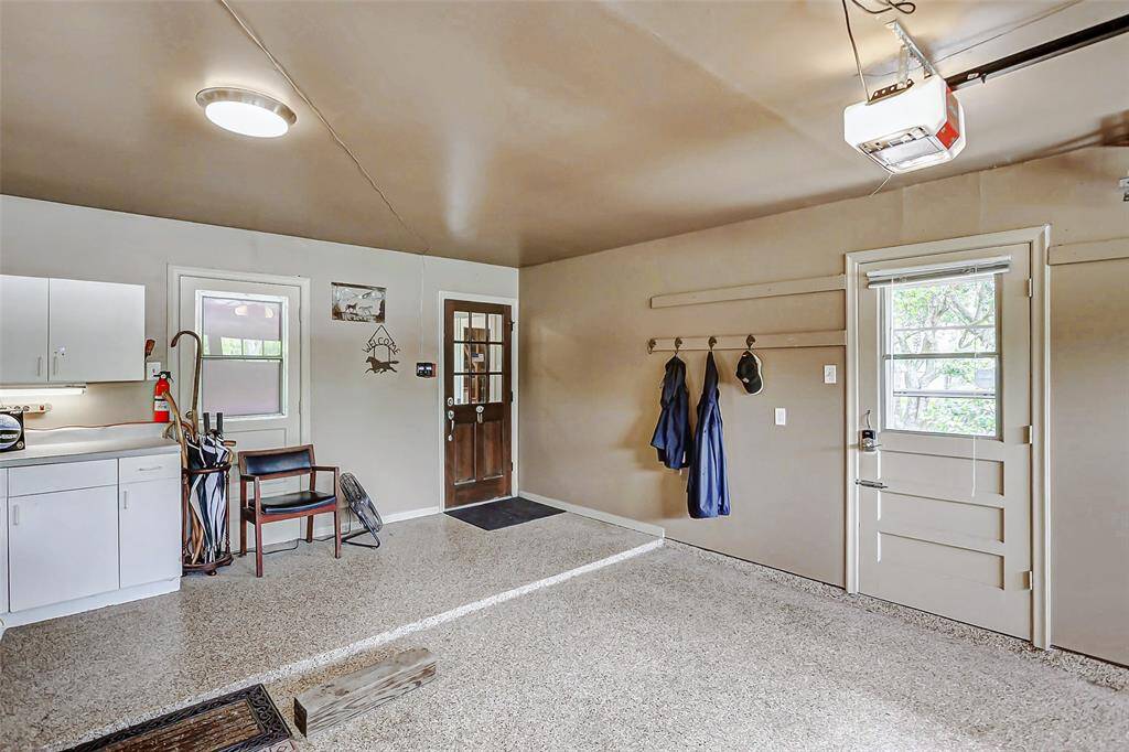 The interior of the garage features epoxy flooring and built in cabinets.
