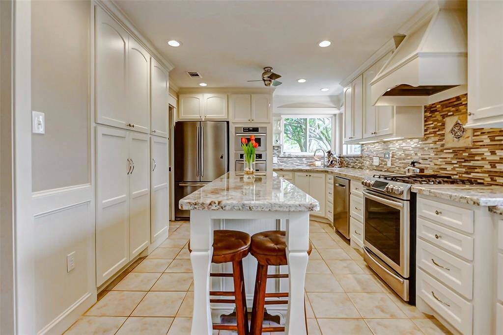 Beautiful view of the upgraded kitchen with large island, custom cabinets and soft closing drawrs.