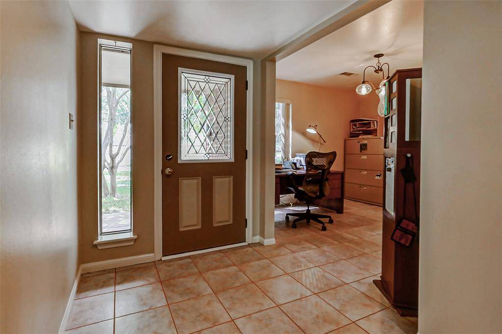Formal entry with custom lead glass door leads in to the current office area.