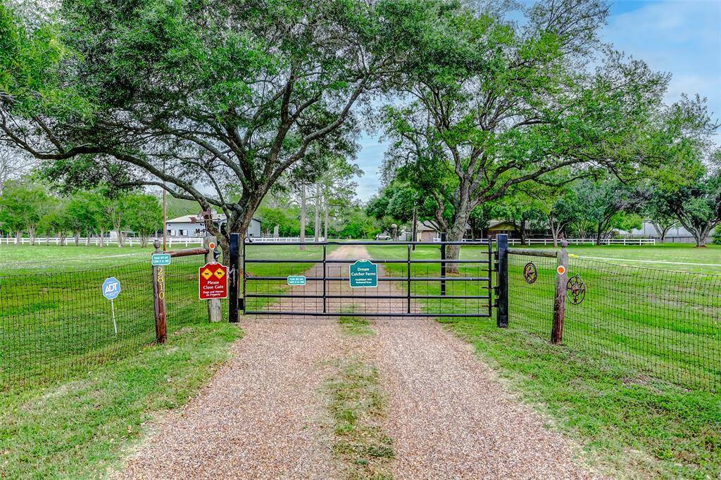 Welcoming gated entrance off of Precinct Line Rd with a majestic tree lined driveway.