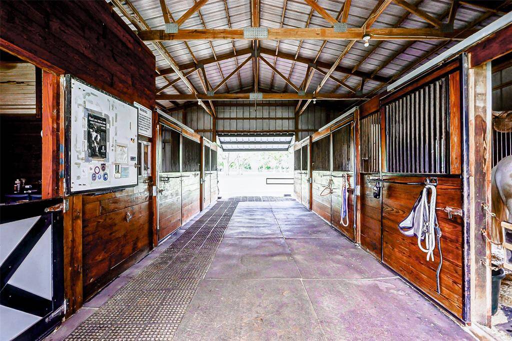 The interior of the barn features 5 stalls, a tack room, feed and hay room and an overhead fly spray system. A dream house for horses!