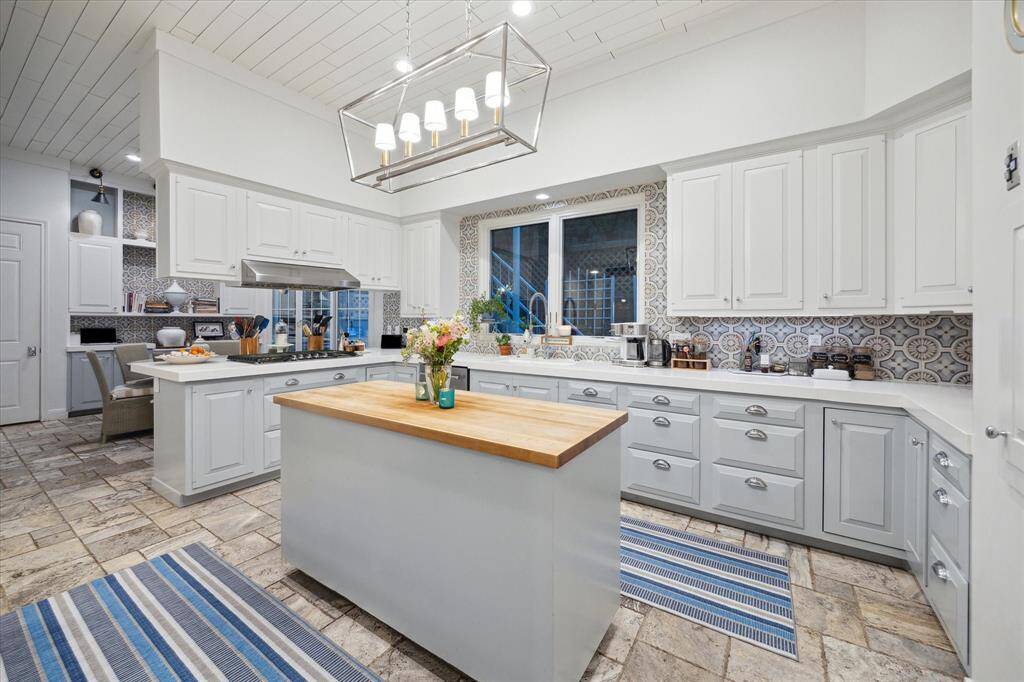 Kitchen has Shiplap ceiling, art lighting, Cobble stone paver flooring, all new appliances and great views of the side yard and greenery.  Center Butcher Block island with an abundance of storage space.  Also present is a Dummy Water that goes to the second floor Primary.