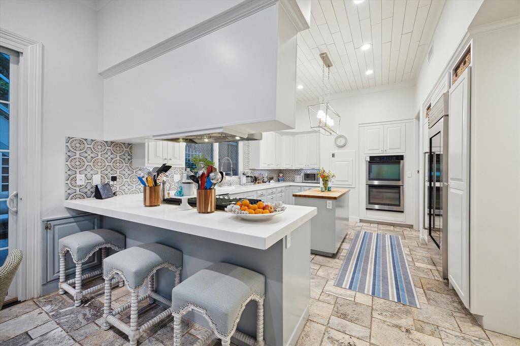 From the Breakfast room you can see the under-counter seating, doggy door, gas cooktop, and double ovens.