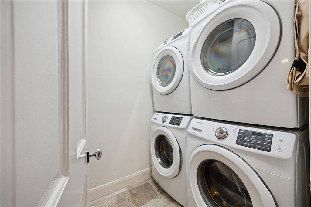 Utility room is adjacent to the Breakfast room and has two full size stackable washer/dryer.  Separate sink and nice built-ins are just behind this door.  Same flooring is continued into this room as well as on step to and from garage.