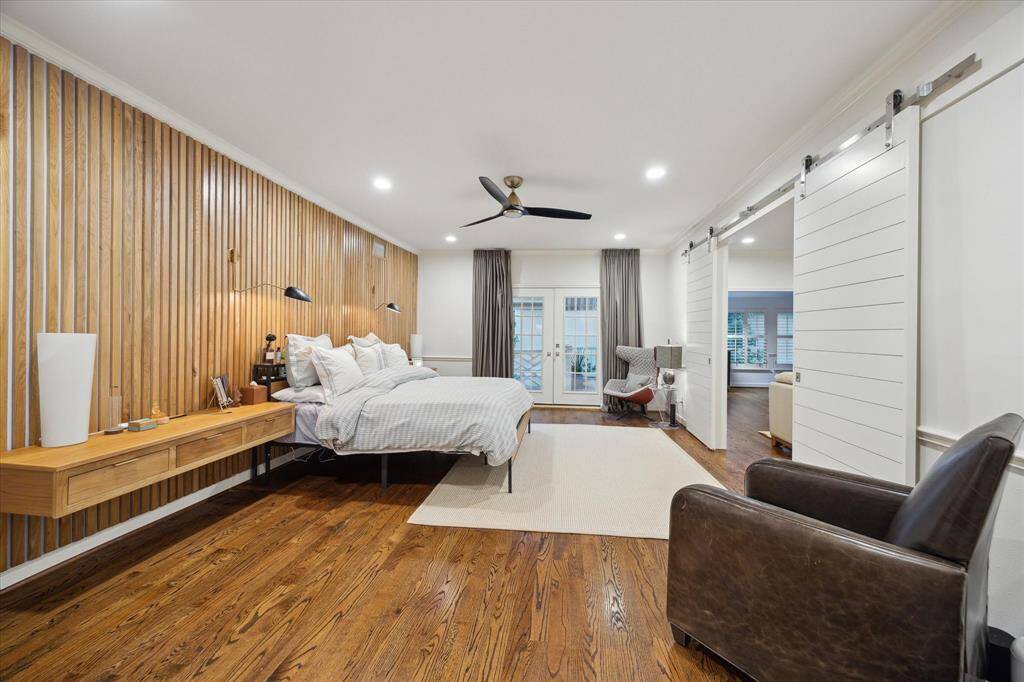 Primary bedroom has a custom made wall of White Oak which we used on the nightstands as well.  The Nightstands can be removed should you wish to change it up a bit.  French doors lead to an outside balcony and double Barn doors of Shiplap close off the Primary Parlor and Study.