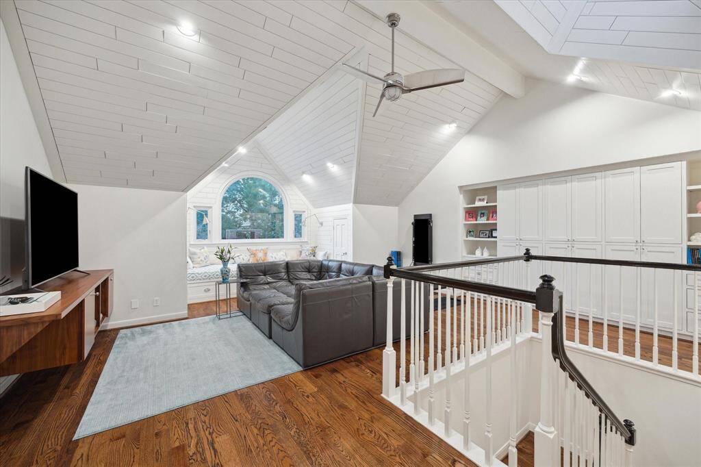 Gorgeous Game Room with high ceiling and Shiplap detail.  Custom wood TV built-in stand, custom wall of built-in for great storage and bookshelves.  This room gets an enormous amount of light from the north and the skylight.