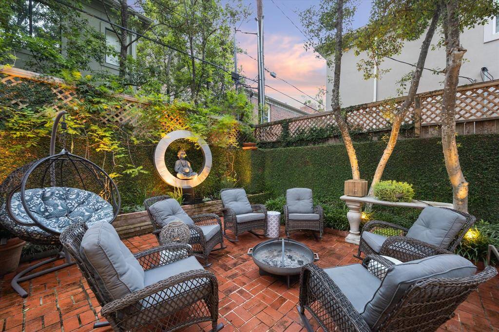 Large and airy backyard space.  This is the perfect inter outdoor firepit scenario.  Holly trees hang overhead and elevated planted provides the space for detailed planting all with gorgeous uplighting.