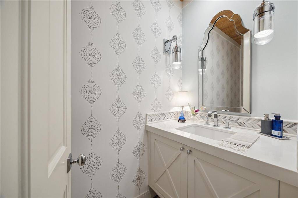 The formal powder is on the opposite side of the house away from the Formal Living and Dining room.  Floating vanity with  custom cabinets, detailed lighting, wood plank ceiling and custom Wallpaper.