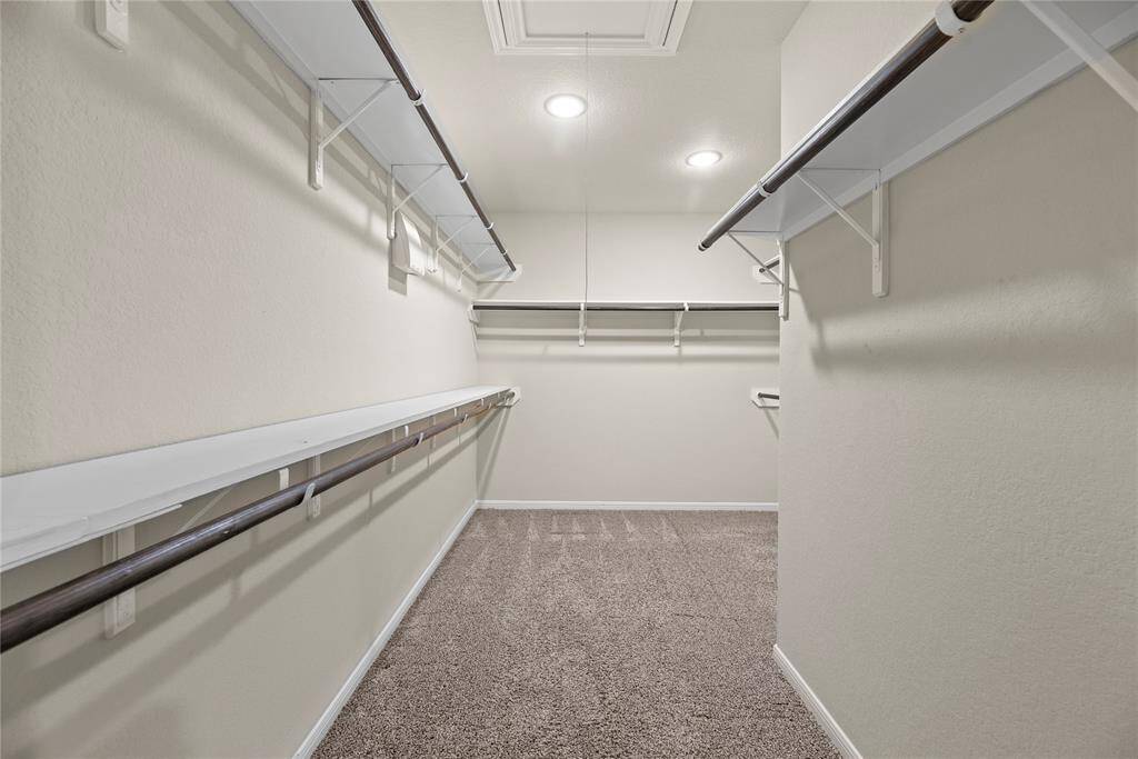 The primary closet offers ample space to store all your clothes and keep everything organized.