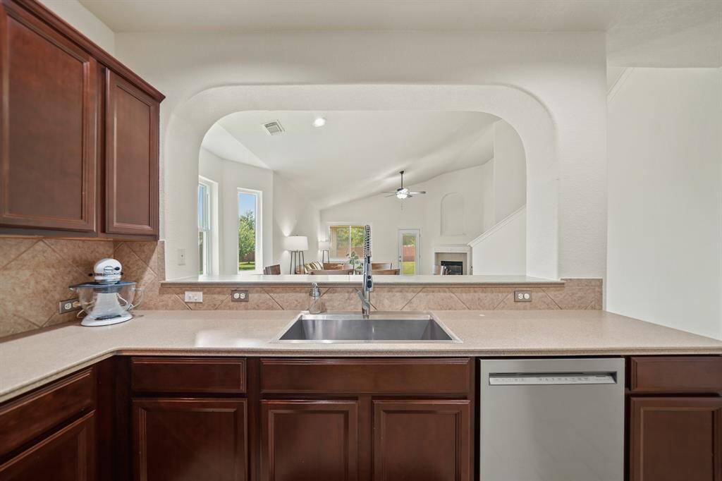 An oversized stainless steel single basin sink is conveniently located near the dishwasher with plenty of counter space on each side.