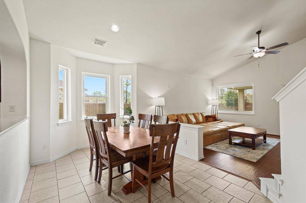 Positioned just between the kitchen and living room, the formal dining room has recessed lighting, a bay of windows overlooking the side yard & tile flooring.