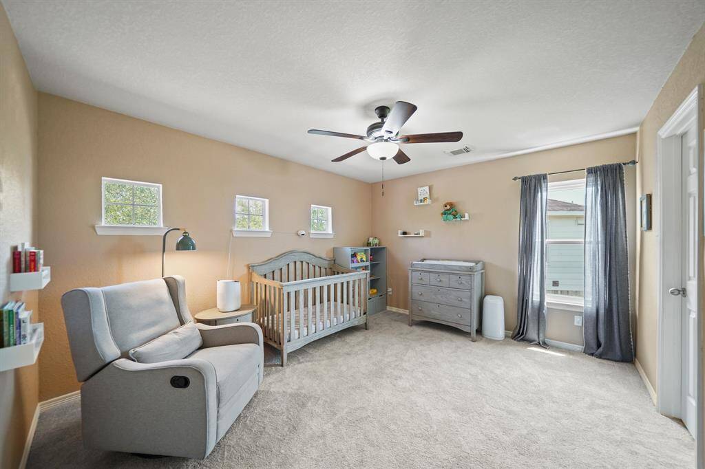 The second bedroom features a ceiling with lighting, window with drapes & carpet and closet on the right.