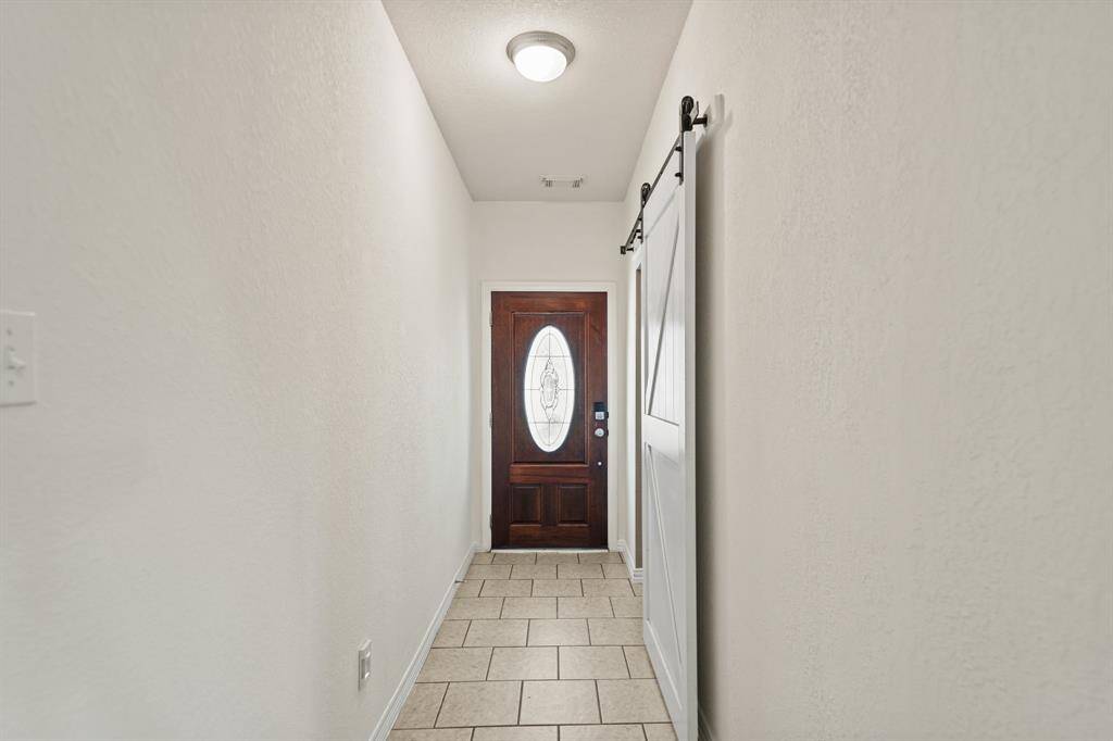 Included is a wood-stained and leaded glass front door with keyless entry and a coat/storage closet is located nearby.