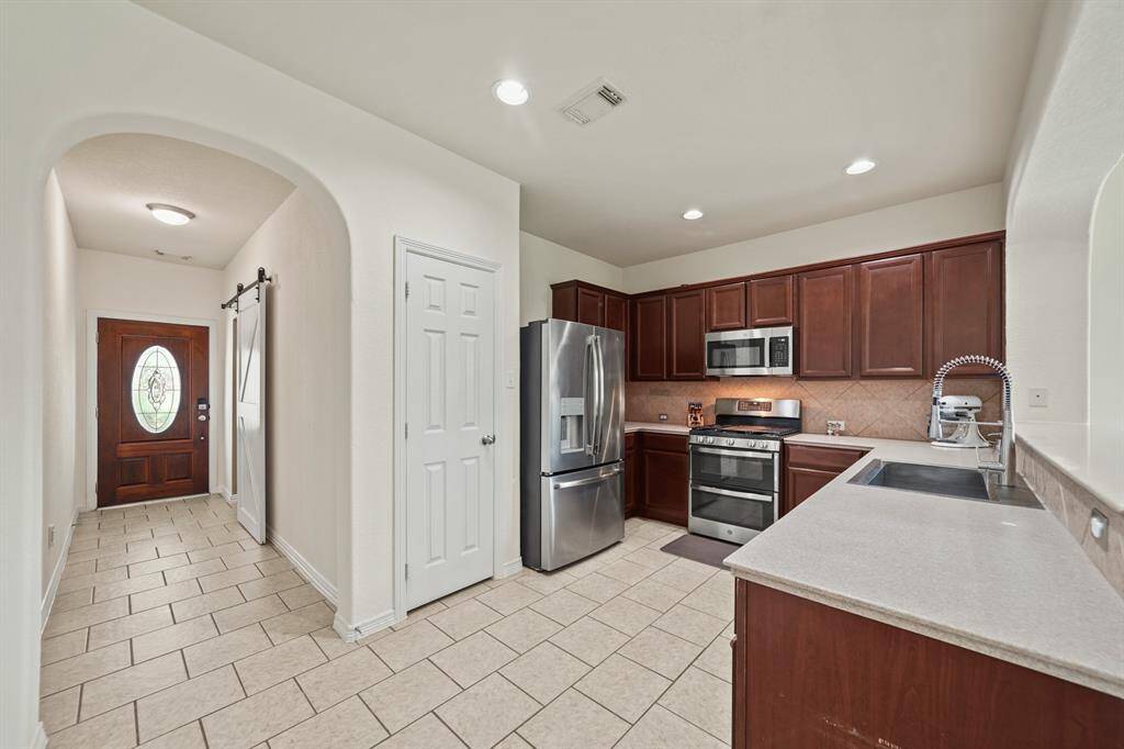 A view of the kitchen with the foyer and private study in the background.