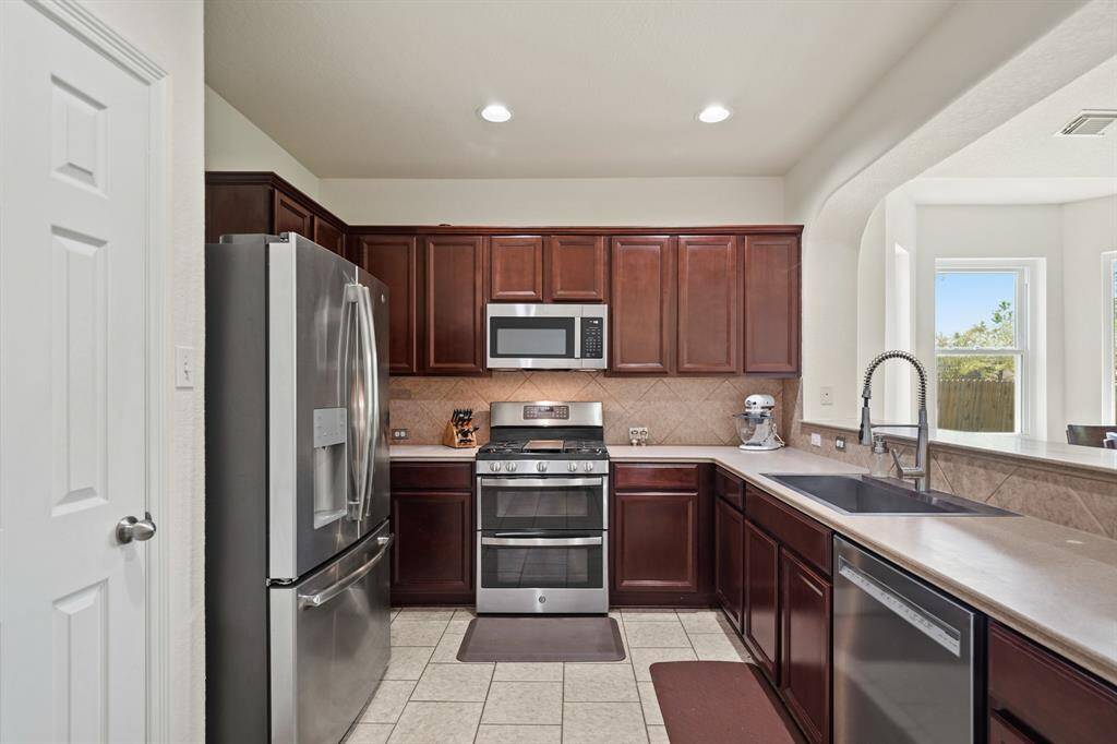 This kitchen offers an abundance of counter, cabinet & drawer storage along with a storage pantry.