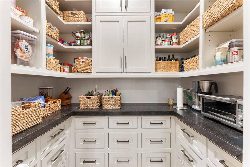 Enjoy a custom walk-in pantry offering an abundance of storage and thoughtfully designed organization.