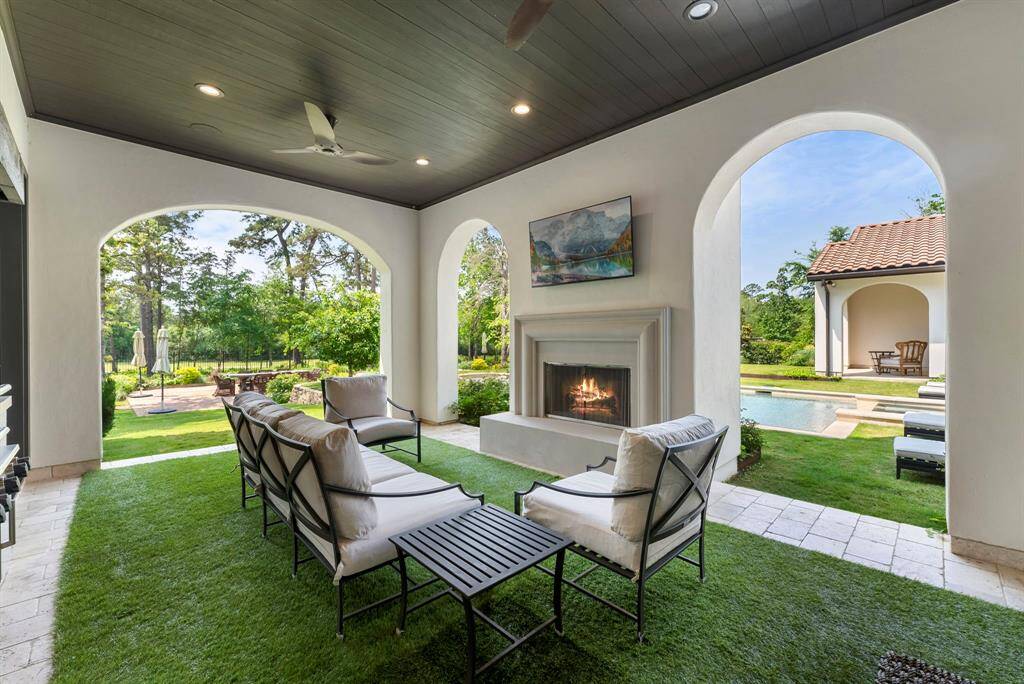 Beyond the breakfast nook, the outdoor patio offers an outdoor kitchen, a charming fireplace framed by graceful archways, and seamless flow to the pool and vast backyard.
