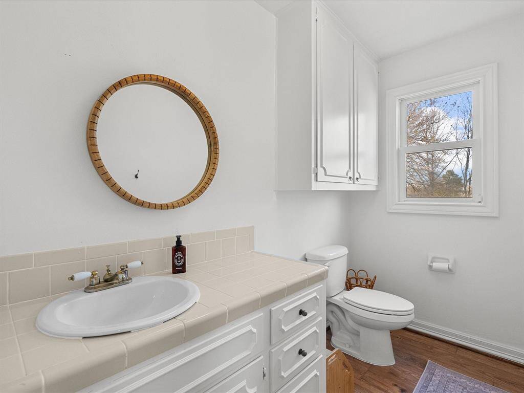This charming en-suite half bath, conveniently located within the secondary bedroom.