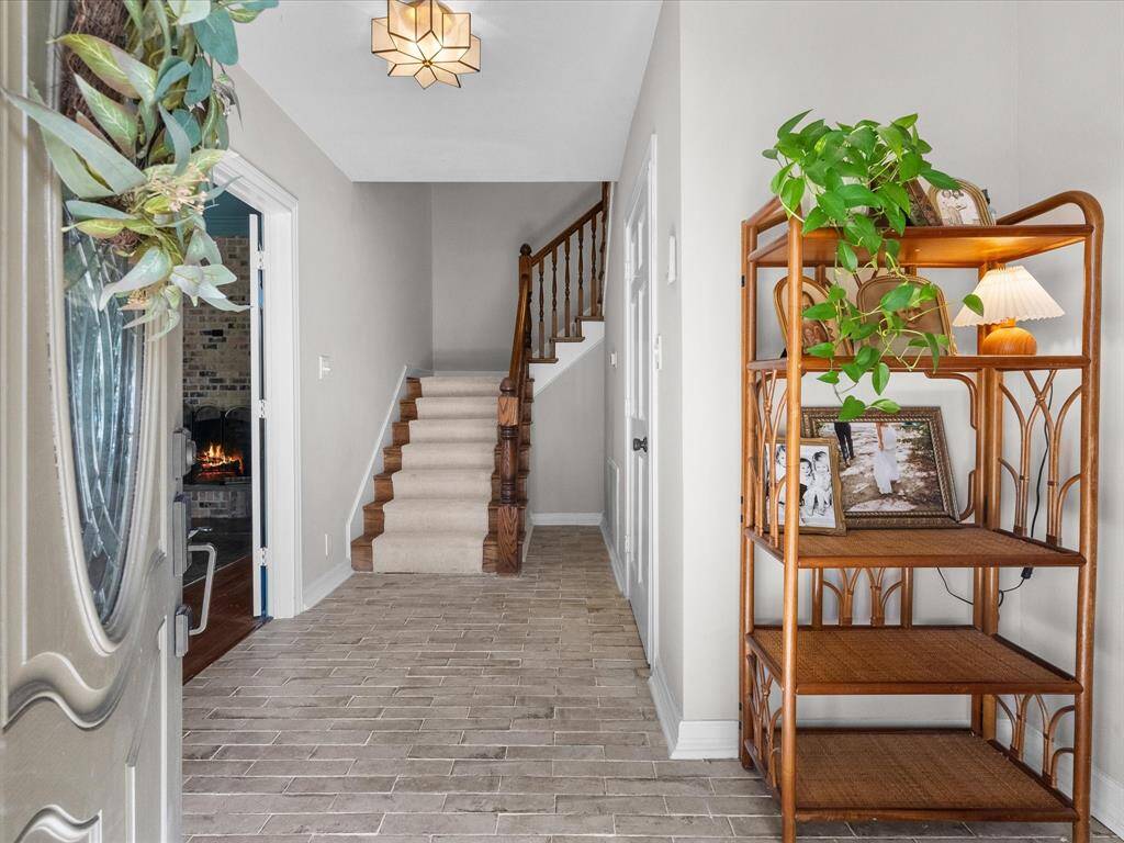 This welcoming foyer sets the tone for the home, featuring high ceilings, abundant natural light.