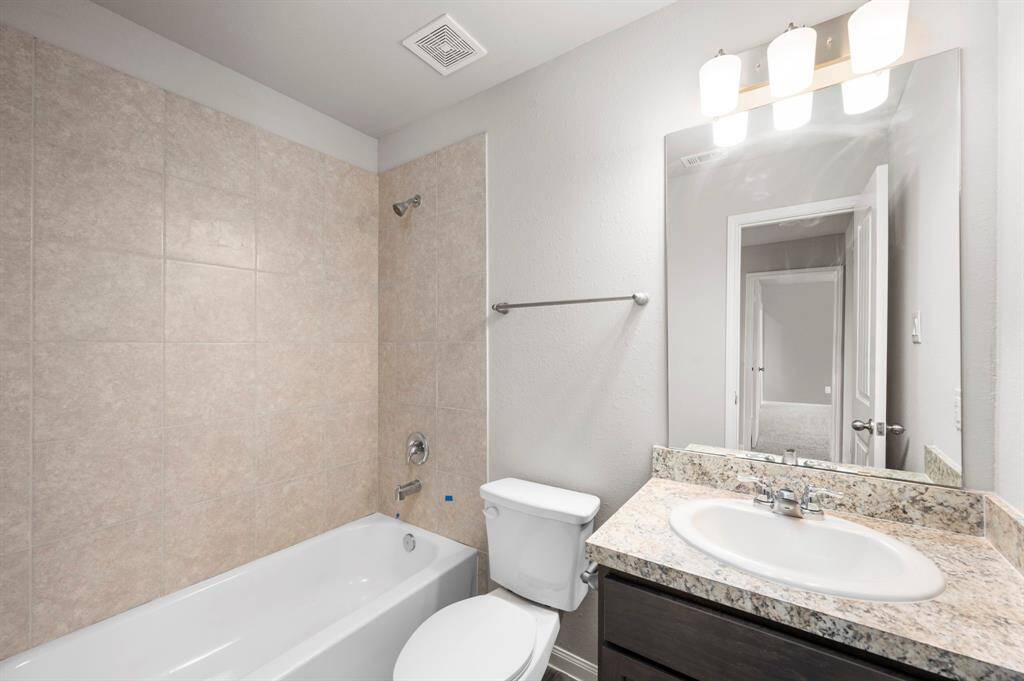 STAGED 2nd bathroom upstairs with single sink vanity and tub.