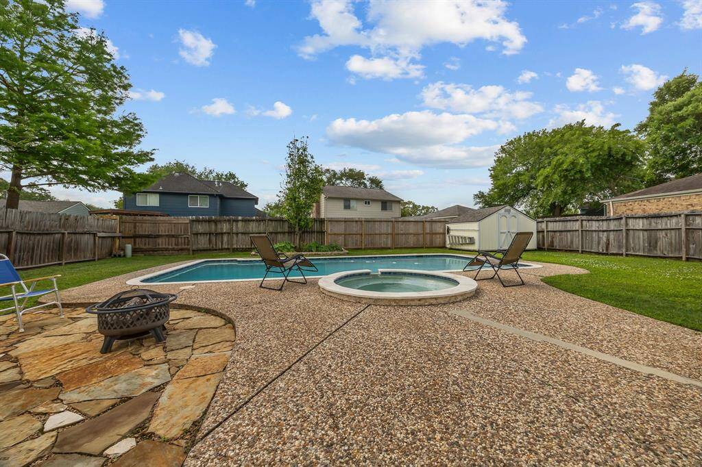 Backyard with Pool with spa and storage shed