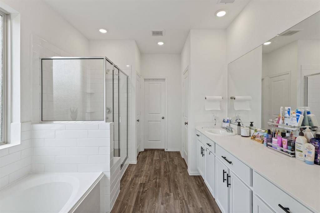 Primary en-suite bathroom that leads into a walk-in closet which has direct and convenient access to the laundry room