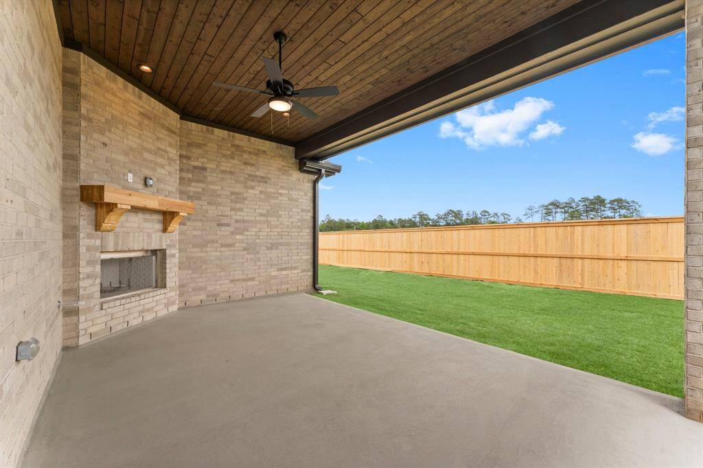 Enjoy Your Covered Rear Patio Year-Round with teh Woodburning Fireplace and Fan