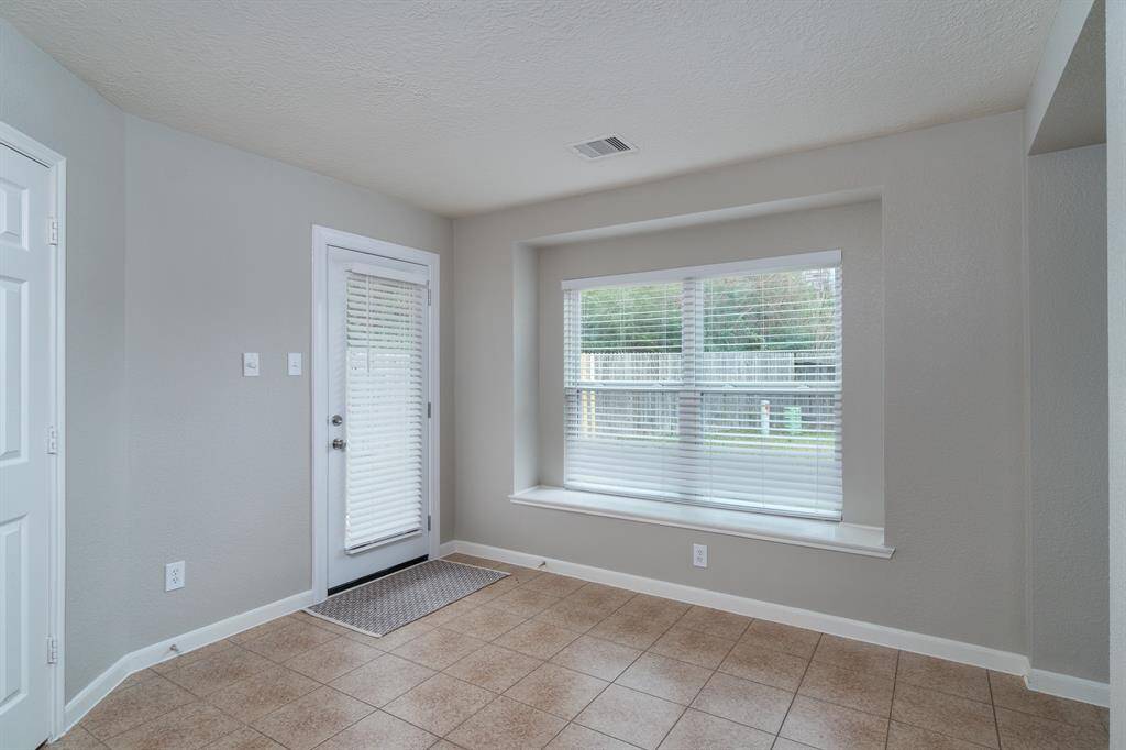 Dining area off kitchen, w/ built-in window seat. Door leads to backyard. Door to pantry on far left.