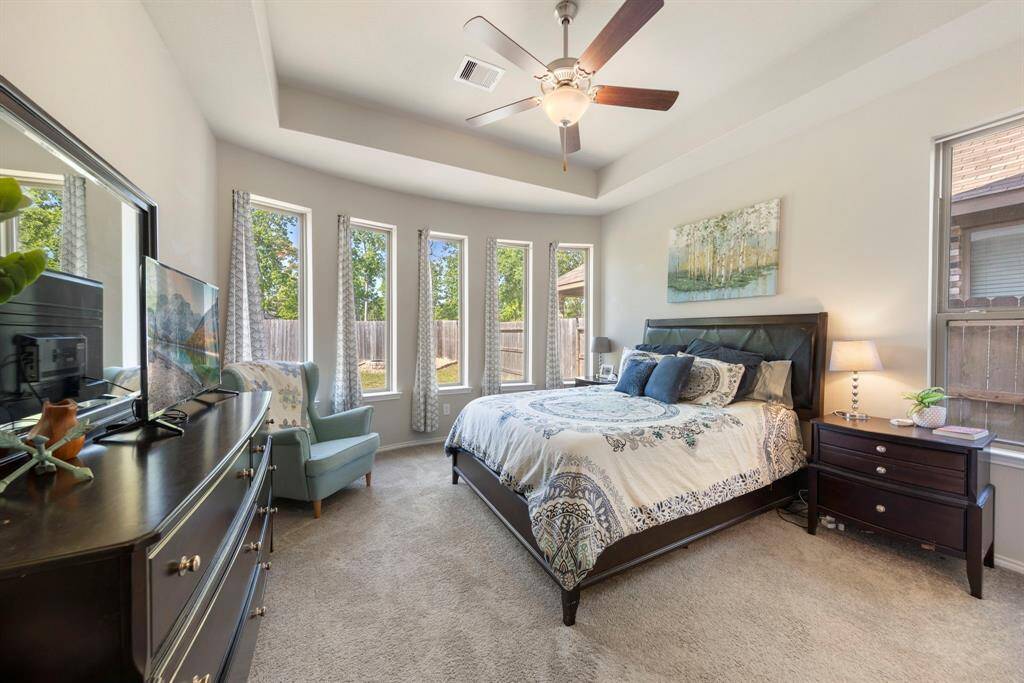 Private primary suite with a tray ceiling and beautiful bay windows.
