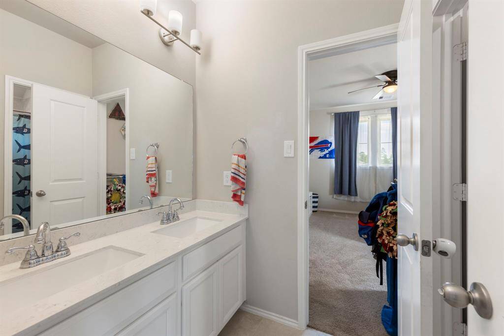 Jack and Jill secondary bathroom with dual sinks and a shower/tub combo.