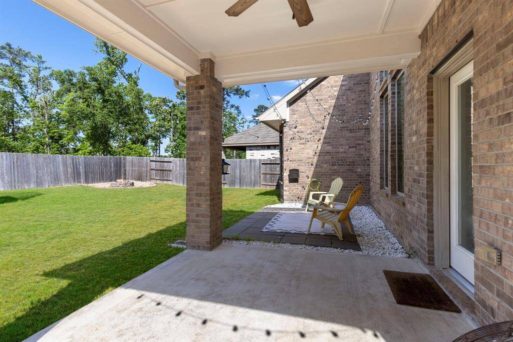 The backyard features a covered patio with a ceiling fan, offering the perfect spot to relax and stay cool.