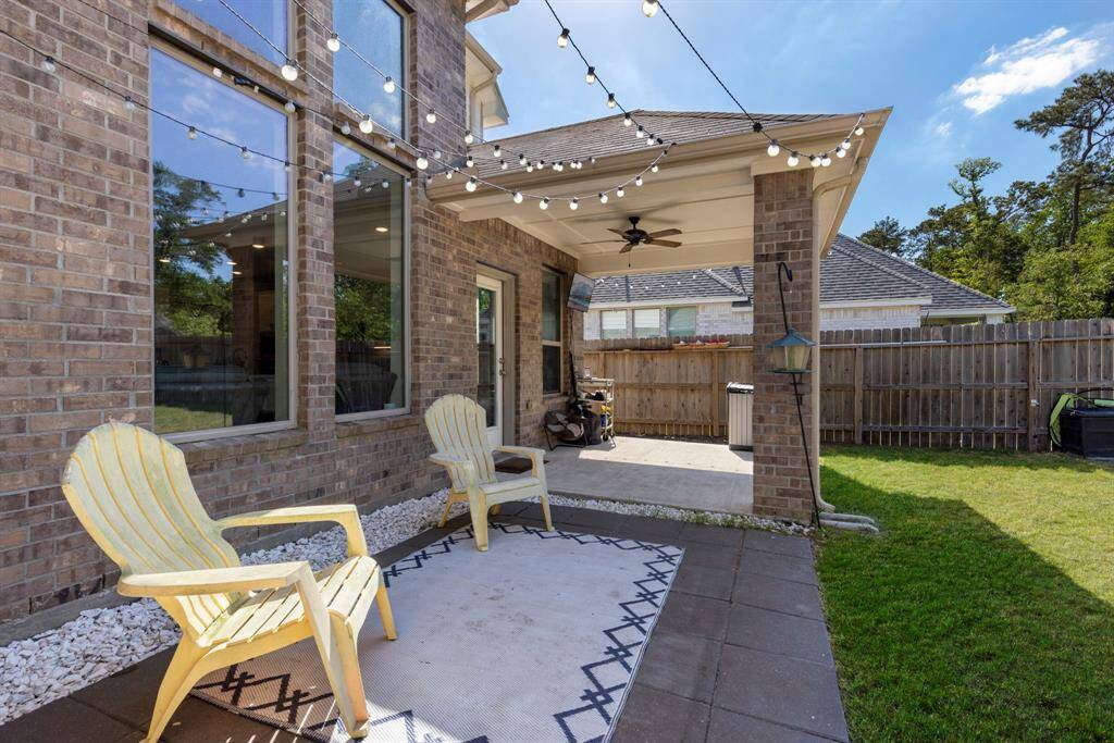 An additional paved area beside the covered patio offers an ideal space for lounging or alfresco dining.
