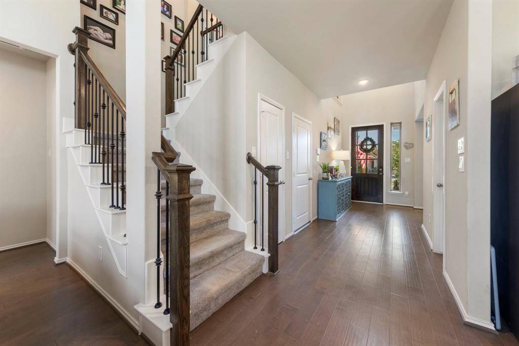 Convenient access to the garage, coat closet, and a stylish half bath, all located near the wood and iron spindle staircase.